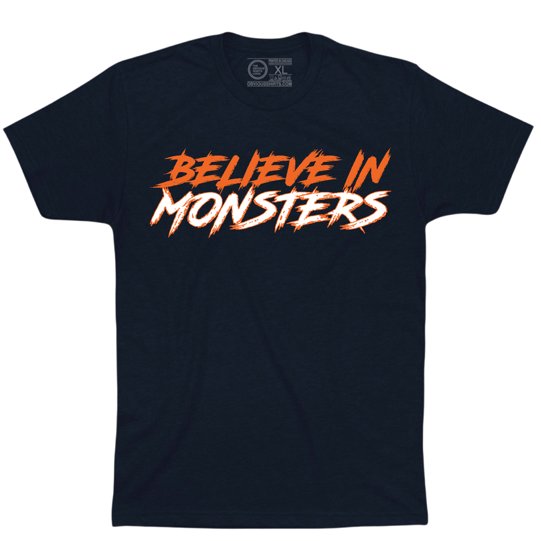 Navy Believe in Monsters T-shirt with orange and white jagged lettering.